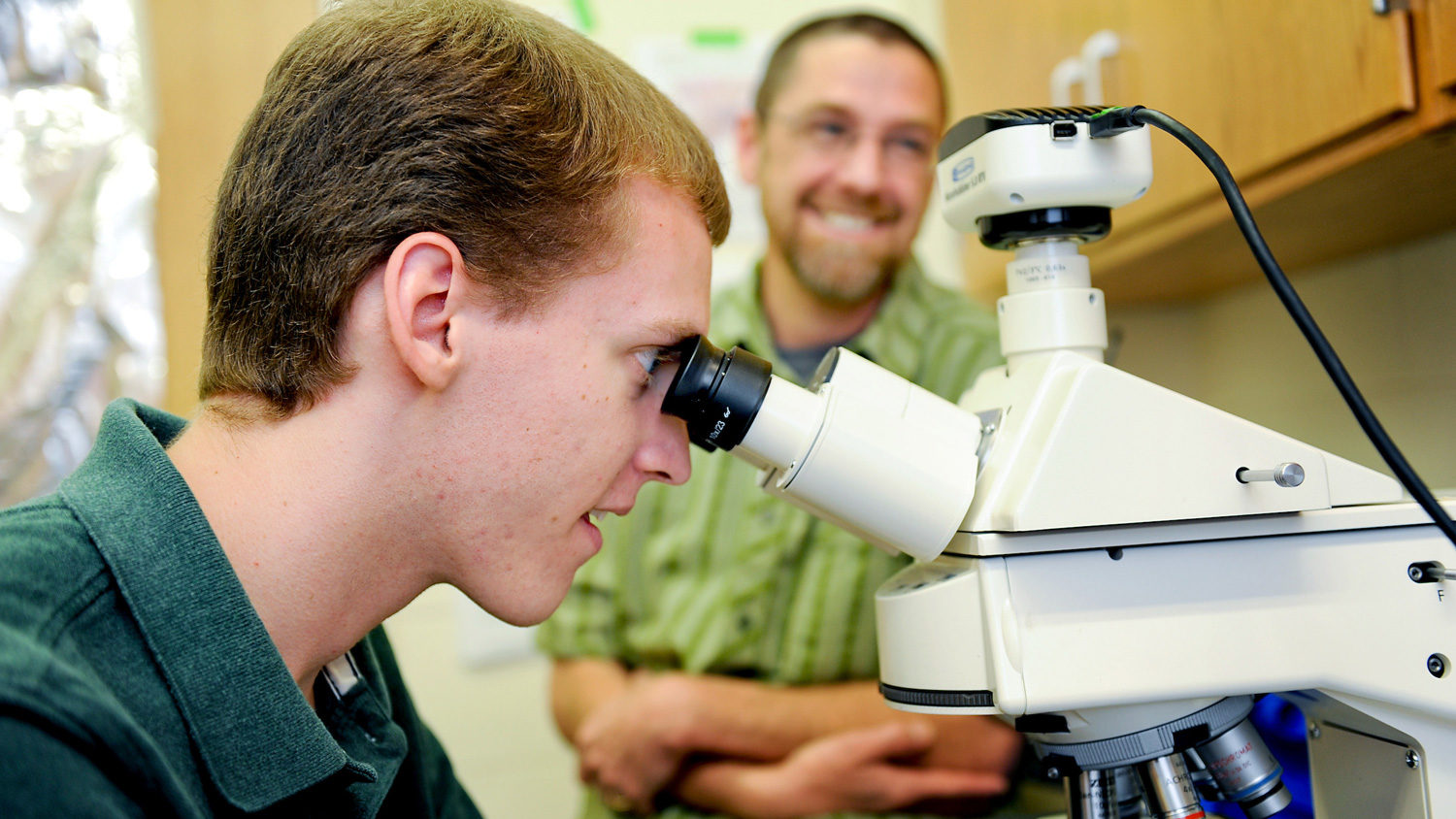 student looking through microscope