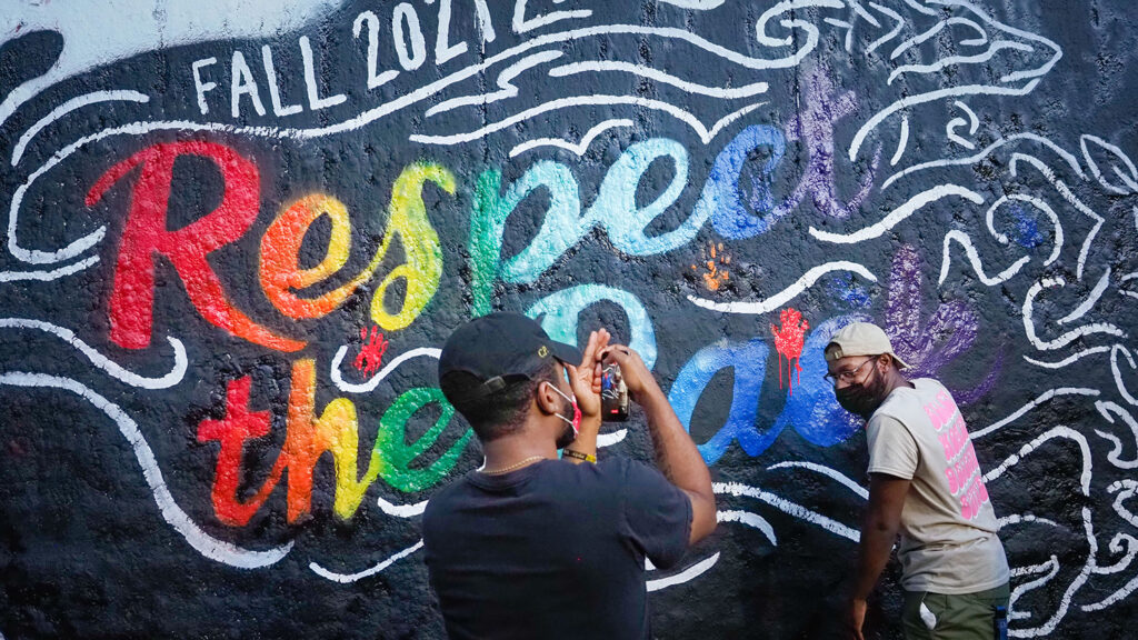 Respect the Pack 2021-- students pose with the mural at the Free Expression Tunnel.